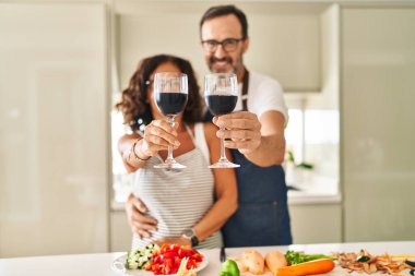 Orta yaşlı İspanyol çift aşçı. Mutfakta şarapla sarılıp kadeh kaldırıyorlar.