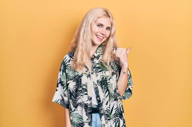 Sarışın, güzel, beyaz bir kadın. Tropikal gömlek giyiyor. Gülümsüyor, gülümsüyor.. 