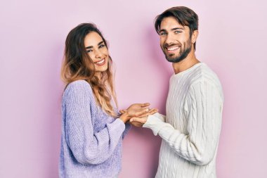 Gündelik giysiler giymiş genç İspanyol bir çift avuçlarını açıp fotokopi alanını gösteriyor ve mutlu bir şekilde gülümsüyor. 