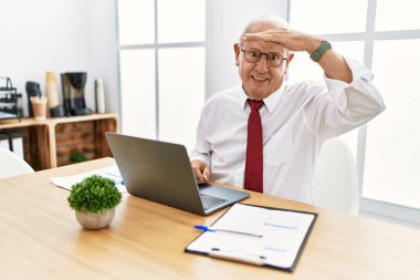 Ofiste çalışan kıdemli bir adam bilgisayarını çok mutlu kullanıyor ve gülümsüyor. arama kavramı. 