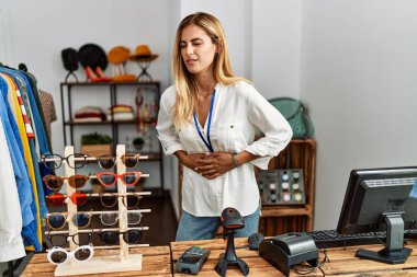 Satış mağazasında yönetici olarak çalışan sarışın, güzel bir kadın midesi üstünde, midesi ağrıyan, hazımsızlık çeken, acı veren bir hastalık yüzünden. Ağrı kavramı. 