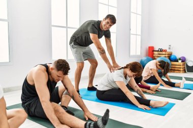 Spor merkezinde kişisel antrenörle antrenman yapan bir grup genç..