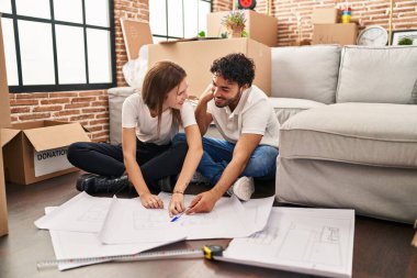 Erkek ve kadın çift gülümsüyor. Yeni ev planları yapıyorlar.