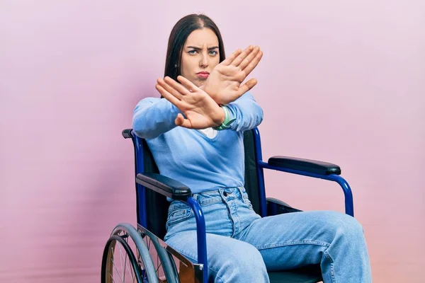 美丽的女人 蓝眼睛坐在轮椅上 拒绝的表情 胳膊和手掌交叉 做着负面的手势 生气的脸 — 图库照片