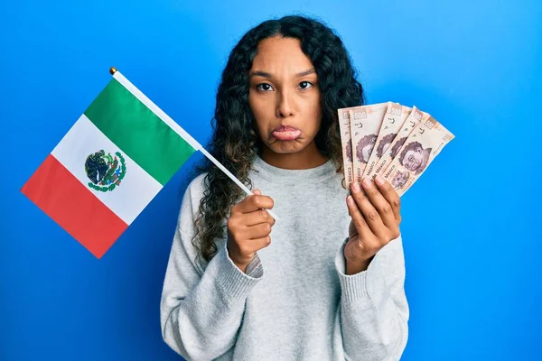 メキシコの国旗とメキシコペソ紙幣を持っている若いラテン語の女性は 怒りと恐怖を泣き 苦痛のために落ち込んで心配しています 悲しい表情 — ストック写真