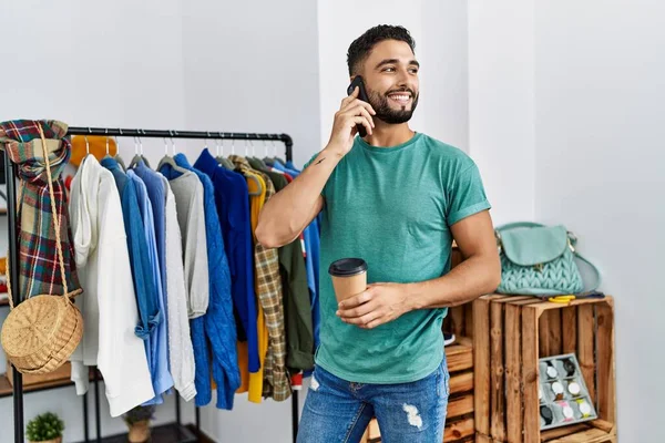 Jonge Araab Man Klant Aan Het Praten Smartphone Stand Kledingrek — Stockfoto