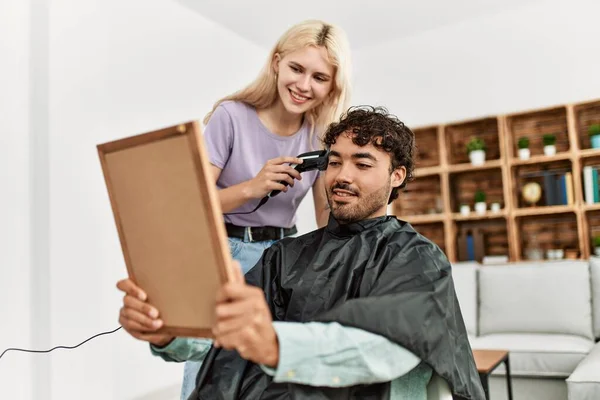 年轻女子在家里给男朋友剪头发 — 图库照片