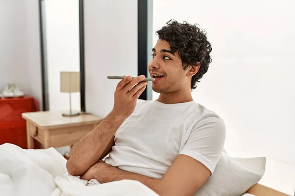 Genç Spanyol Adam Akıllı Telefonda Konuşuyor Yatak Odasında Yatakta Oturuyor — Stok fotoğraf