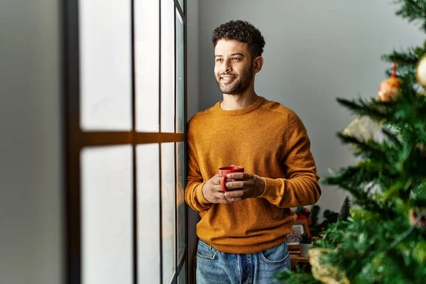 Young Arab Man Drinking Coffee Standing Christmas Tree Home — Stock Photo, Image