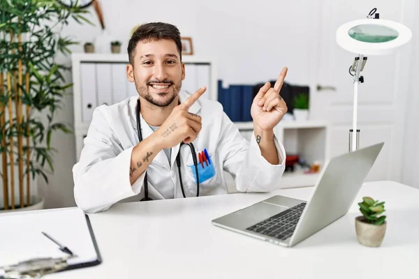 Jovem Médico Trabalhando Clínica Usando Laptop Computador Sorrindo Olhando Para — Fotografia de Stock