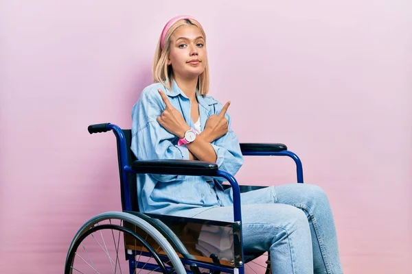 Beautiful Blonde Woman Sitting Wheelchair Pointing Both Sides Fingers Different — Stok fotoğraf