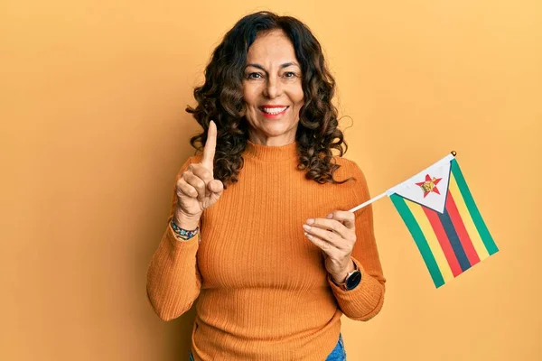 Middelbare Leeftijd Spaanse Vrouw Met Zimbabwe Vlag Glimlachend Met Een — Stockfoto