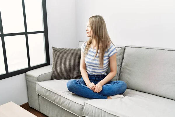 Asiática Jovem Mulher Sentada Sofá Casa Olhando Para Lado Relaxar — Fotografia de Stock