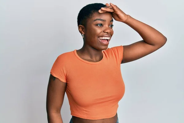 年轻的非洲裔美国女人穿着休闲的橙色T恤 非常高兴 面带微笑地看着远方 手牵着手 搜索概念 — 图库照片