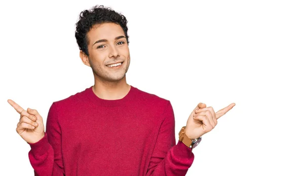 若いハンサムな男が別の方向に指で自信を持って指して笑顔カジュアルな服を着ている 広告のコピースペース — ストック写真