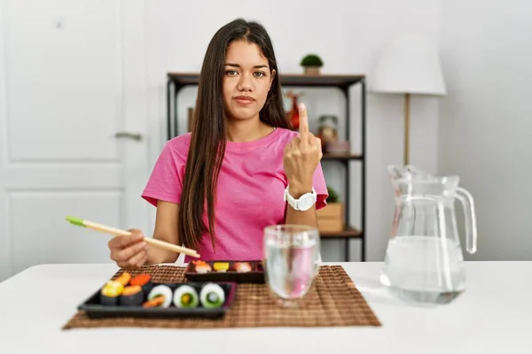 Young Brunette Woman Eating Sushi Using Chopsticks Showing Middle Finger — ストック写真