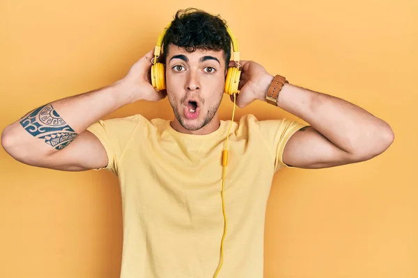 Ung Latinamerikansk Man Lyssnar Musik Med Hörlurar Rädda Och Chockade — Stockfoto