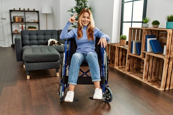 Jovem Mulher Bonita Sentada Cadeira Rodas Casa Sorrindo Gestos Confiantes — Fotografia de Stock