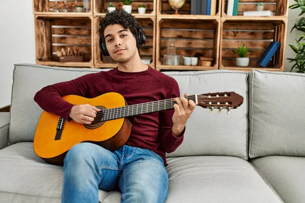 Joven Hispano Tocando Guitarra Clásica Sentado Sofá Casa — Foto de Stock