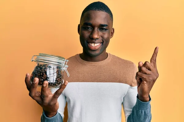 Joven Hombre Afroamericano Sosteniendo Frasco Con Granos Café Sonriendo Feliz — Foto de Stock
