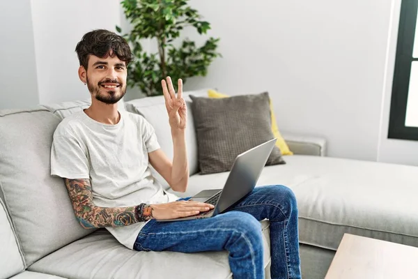 Homem Hispânico Com Barba Sentado Sofá Mostrando Apontando Para Cima — Fotografia de Stock