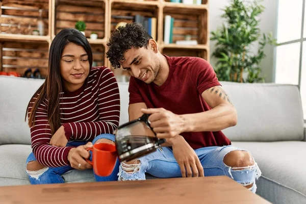 Young Latin Couple Smiling Happy Drinking Coffee Sitting Sofa Home — Stock fotografie