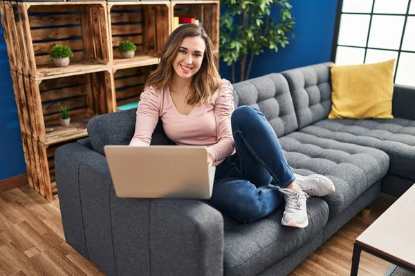 Mujer Joven Usando Ordenador Portátil Sentado Sofá Casa —  Fotos de Stock