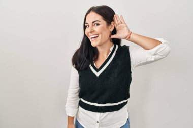 Tecrit edilmiş arka planda dikilen genç İspanyol kadın kulağına fısıldayarak dedikoduları ve dedikoduları dinliyor. Sağırlık kavramı. 