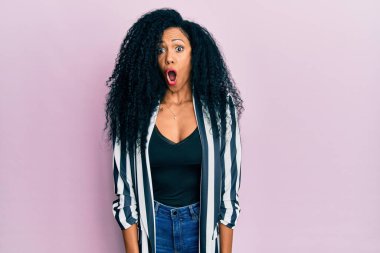 Orta yaşlı Afro-Amerikalı kadın günlük kıyafetler giyiyor. Şaşırtıcı bir ifade, korku ve heyecan dolu bir yüz ifadesi var.. 