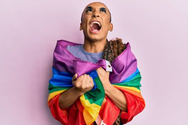 Makyaj yapan İspanyol bir adam ve gökkuşağına sarılı uzun saçlı kızgın ve kızgın bir şekilde bağıran öfkeli ve öfkeliydi. Öfkeyle bağırıyordu.. 