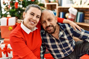 Genç kız ve büyük baba Noel 'i evde kutluyor, Noel ağacının yanında şenlikli süslerin etrafında oturuyor.