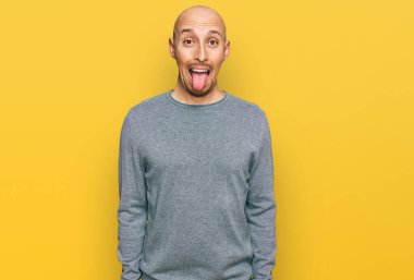 Kel, sakallı, sıradan kıyafetler giyen, dilini dışarı çıkaran, komik bir ifade takınan bir adam. duygu kavramı. 