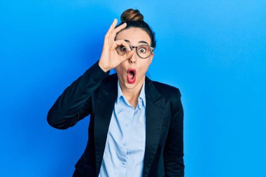 İş kıyafetleri ve gözlük takan genç İspanyol kız şaşırmış yüz ifadesiyle şaşırmış, parmaklarından bakan gözler. İnançsız ifade. 