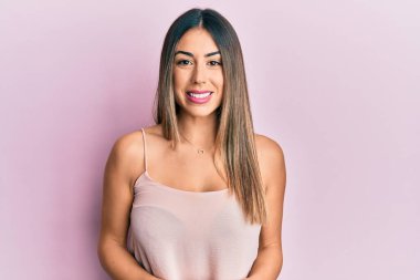 Genç İspanyol kadın kolsuz tişört giyiyor ve yüzünde mutlu ve havalı bir gülümseme var. şanslı kişi. 