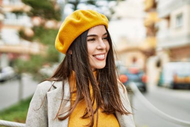 Genç İspanyol kız gülümseyerek şehirde mutlu mesut dikiliyor..