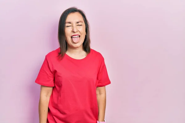 変な表情で嬉しそうに舌を突き出しているカジュアルな服を着た中年のヒスパニック系女性 感情の概念 — ストック写真