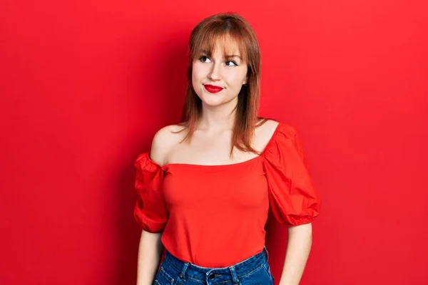 Kırmızı Tişörtlü Kızıl Saçlı Genç Bir Kadın Gülümseyip Yan Tarafa — Stok fotoğraf