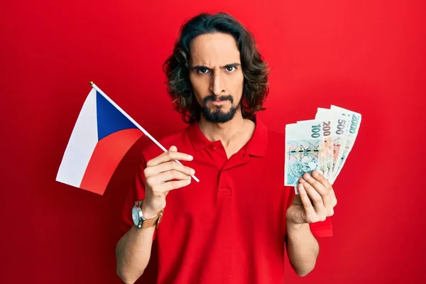 Joven Hispano Sosteniendo Bandera República Checa Billetes Coronas Escéptico Nervioso —  Fotos de Stock
