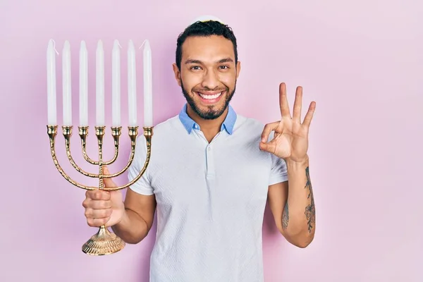 Hispanic Man Beard Holding Menorah Hanukkah Jewish Candle Doing Sign — Stock Photo, Image