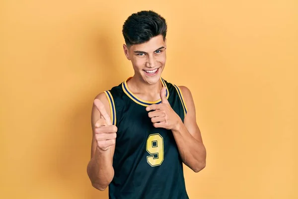 Молодой Латиноамериканец Баскетбольной Форме Указывает Пальцем Камеру Счастливым Смешным Лицом — стоковое фото
