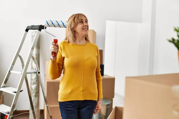 Middle Age Blonde Woman Using Paint Roller New Home — Stockfoto