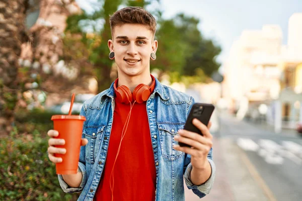 若い白人男性飲料ソーダを使用してスマートフォンで市内 — ストック写真