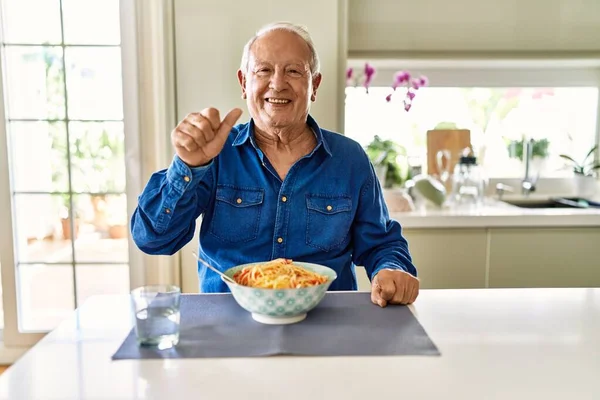 Homem Sênior Com Cabelos Grisalhos Comendo Espaguete Casa Mostrando Apontando — Fotografia de Stock