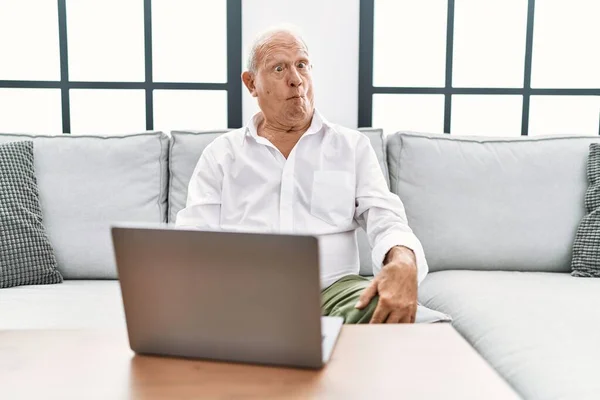 Evde Dizüstü Bilgisayar Kullanan Kıdemli Bir Adam Kanepede Oturup Dudağıyla — Stok fotoğraf