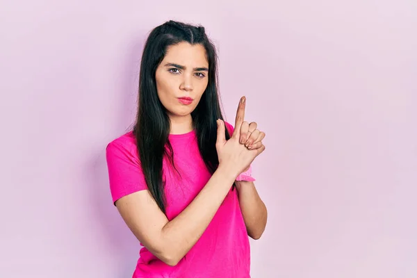 Chica Hispana Joven Con Camiseta Rosa Casual Sosteniendo Arma Simbólica — Foto de Stock