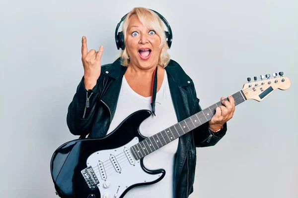 Mujer Rubia Mediana Edad Tocando Guitarra Eléctrica Haciendo Cuernos Signo —  Fotos de Stock