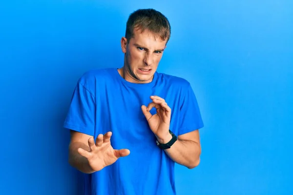 身穿休闲蓝色T恤的年轻的高加索人厌恶表情 因为厌恶的反应而不高兴 害怕做厌恶的事 — 图库照片