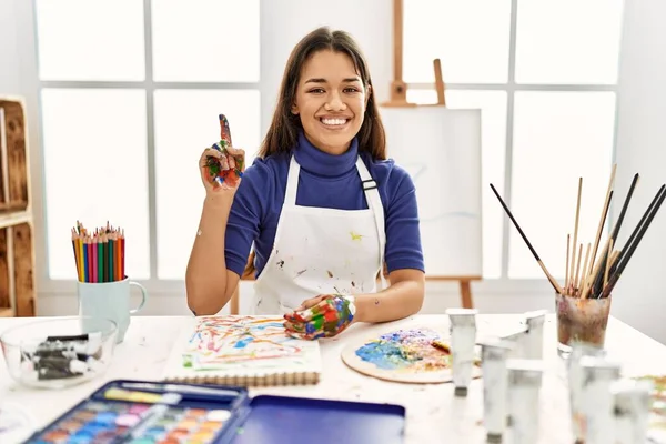 在艺术工作室里 年轻的黑发女人 手绘彩绘 带着第一指尖 面带微笑 自信而快乐 — 图库照片