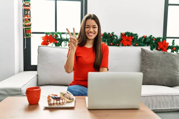 Jovem Morena Usando Laptop Sentado Sofá Natal Mostrando Apontando Para — Fotografia de Stock