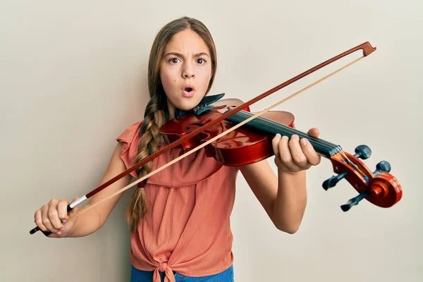 Красивая Брюнетка Играющая Скрипке Шокирующем Лице Выглядящая Скептически Саркастично Удивленная — стоковое фото